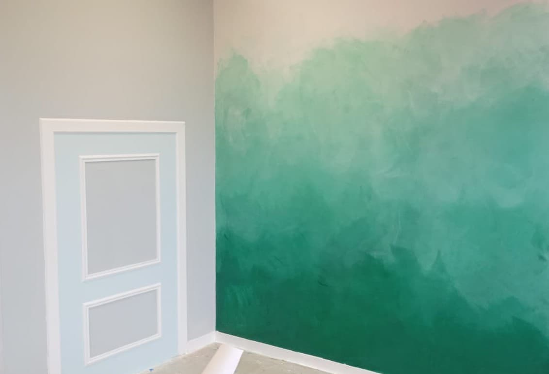 Mur peint en camaïeu de verts, du vert profond en bas au blanc en haut, travaillé au spalter et au blaireau